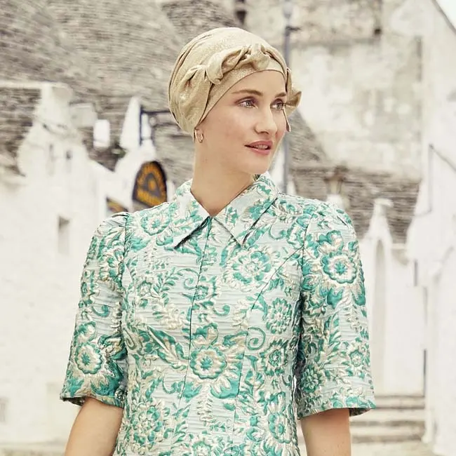 Frau mit gemustertem Beatrice-Turban im Sonnenlicht